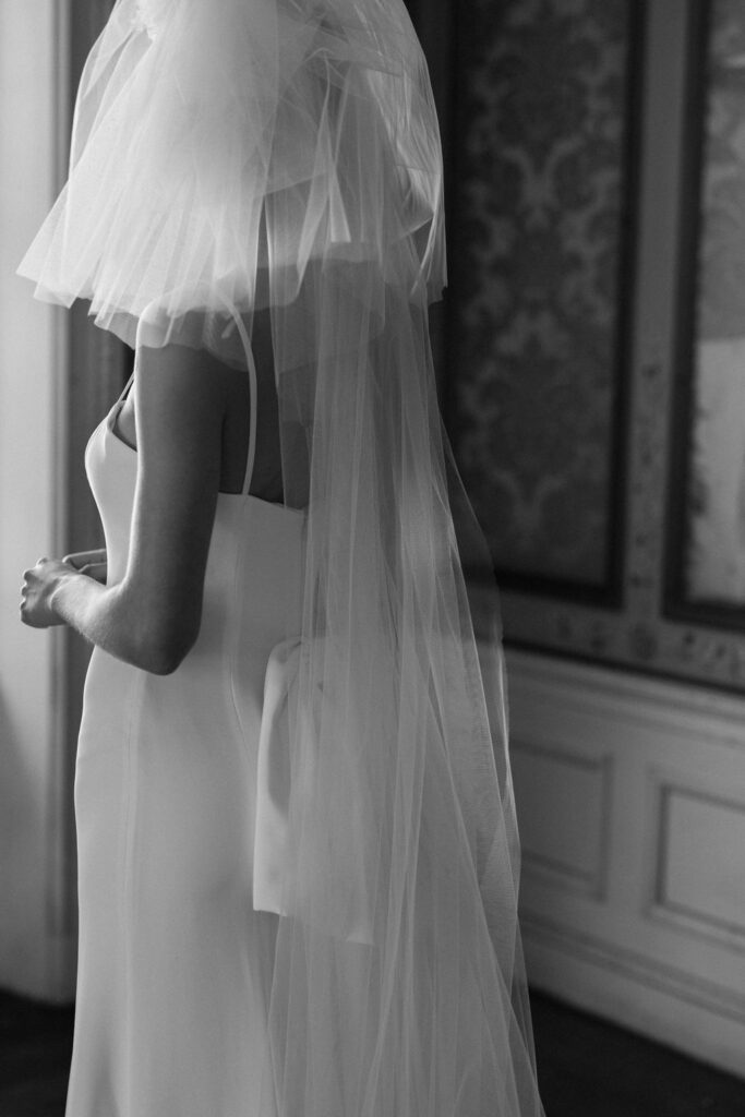 black and white image of bride in wedding dress and veil