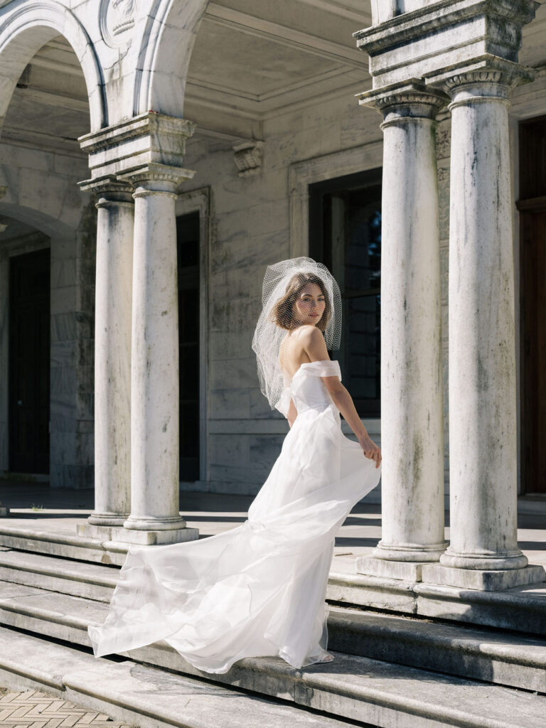 bride twirling wedding dress outside of a mansion